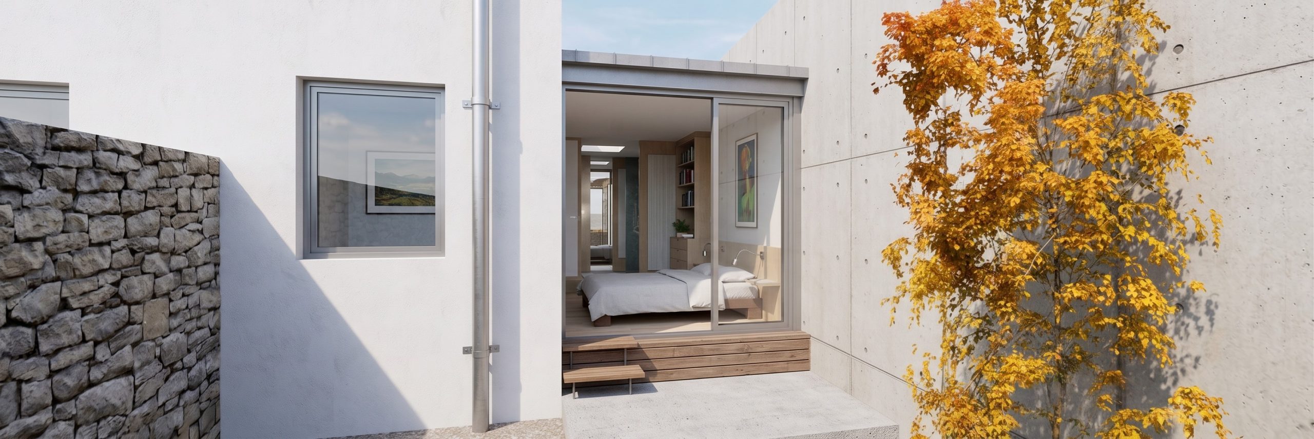 Vista exterior de patio privado y acceso a dormitorio suite en ampliación en Torrelodones, con ventanal corredero con tarima de madera, muro de hormigón visto, mampostería de piedra y árbol caducifolio de hojas amarillas, por Espacio Acorde.