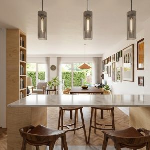 Vista desde la cocina hacia el salón-comedor tras la reforma integral de una vivienda en Alcalá Norte (Madrid), mostrando barra de mármol con taburetes de madera, luminarias cilíndricas suspendidas, suelo de espiga y salida al jardín ajardinado, por Espacio Acorde.