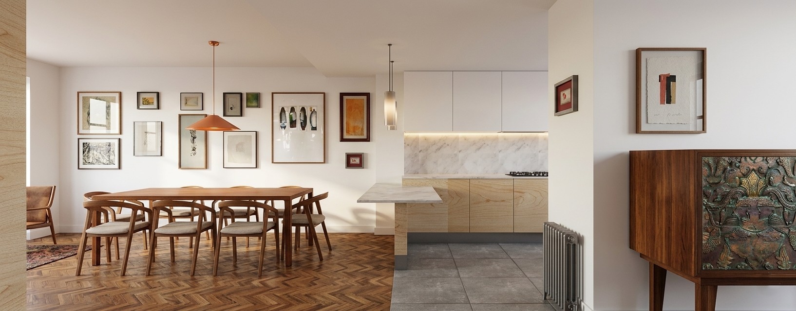 Vista frontal de la zona de comedor con mesa de madera y galería de cuadros en pared, junto a la cocina abierta con península de mármol, armarios superiores blancos y pavimento cerámico gris en vivienda de Alcalá Norte (Madrid), por Espacio Acorde.