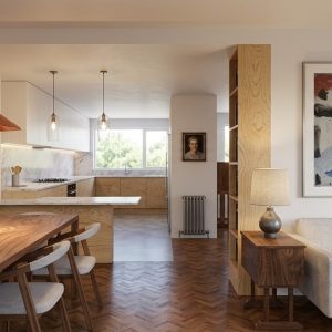 Vista de la zona de día de una vivienda en Alcalá Norte (Madrid), con comedor de madera a la izquierda, área de estar con sofá claro y cuadros a la derecha, columna librería en madera y cocina semiabierta al fondo con ventana exterior, por Espacio Acorde.