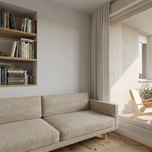Fotografía de zona de estar en piso reformado en Madrid, con sofá neutro, librería empotrada en pared, aplique de lectura y terraza soleada al fondo, por Espacio Acorde.