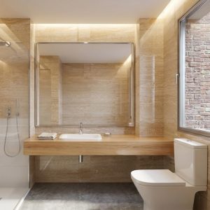 Fotografía de cuarto de baño reformado en Madrid con revestimiento imitación travertino, encimera de madera suspendida, gran espejo con luz led fosa y mampara de ducha de cristal, por Espacio Acorde.