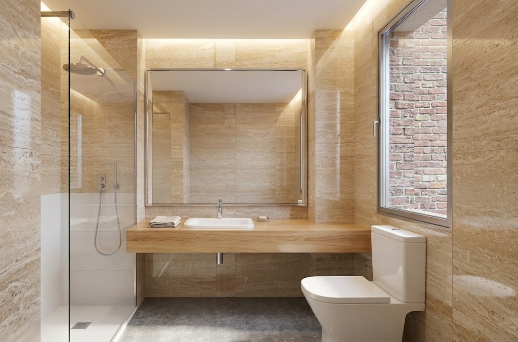 Fotografía de cuarto de baño reformado en Madrid con revestimiento imitación travertino, encimera de madera suspendida, gran espejo con luz led fosa y mampara de ducha de cristal, por Espacio Acorde.