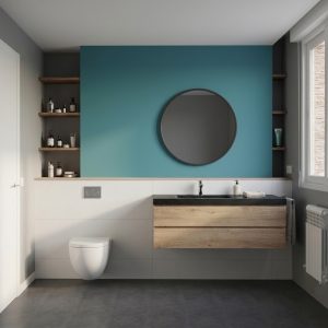 Vista frontal de baño reformado en Madrid con pared azul, espejo redondo, inodoro suspendido y mueble de lavabo de madera volado, por Espacio Acorde.