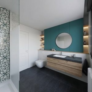 Perspectiva de baño reformado en Madrid con pared decorativa hidráulica en la ducha, mueble de madera suspendido, espejo redondo y pared azul, por Espacio Acorde.