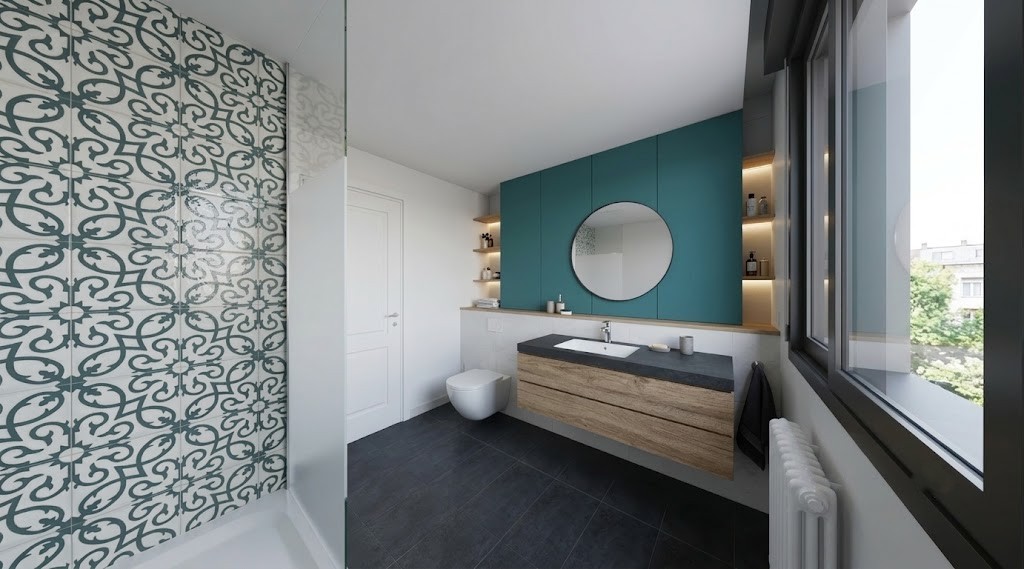 Perspectiva de baño reformado en Madrid con pared decorativa hidráulica en la ducha, mueble de madera suspendido, espejo redondo y pared azul, por Espacio Acorde.